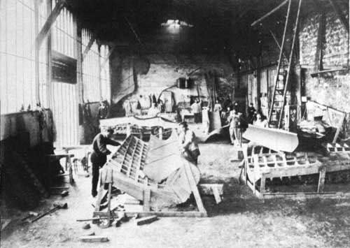 workmen hammering sheets of copper into shape
